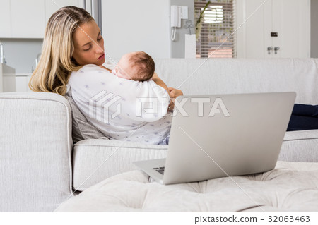 Mother consoling her baby in living room 32063463