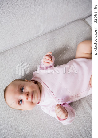 Baby lying on sofa in living room 32063466