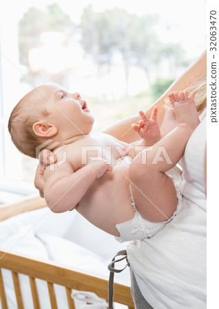 Mid-section of mother holding her baby boy Mid-section of mother holding her baby boy 32063470