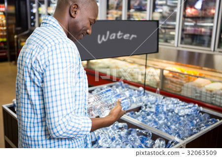 Man looking at bottle of water Man looking at bottle of water 32063509