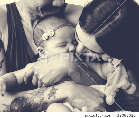 Father and mother are taking care of their child. 32065026