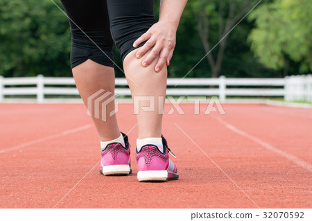 Middle aged woman runner muscle pain during train 32070592