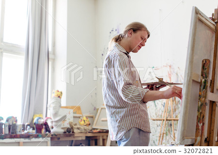 Creative male artist drawing picture oil paints 32072821