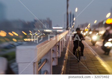 A boy riding a bike on a bridge. A boy riding a bike on a bridge. 32073402