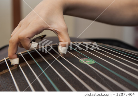 A girl is playing Guzheng. A girl is playing Guzheng. 32073404