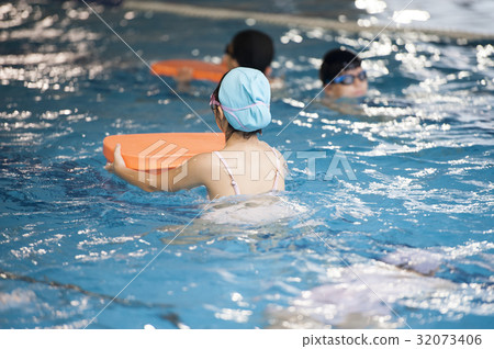 Child holding a floating board swim in the pool Child holding a floating board swim in the pool 32073406