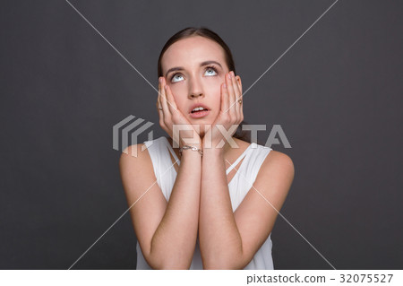 Bored girl rolling her eyes and touch cheeks 32075527