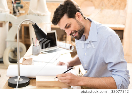 Cheerful bearded lumber master working with wooden Cheerful bearded lumber master working with wooden 32077542