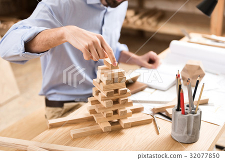 Pleasant woodworker is resting at his job 32077850