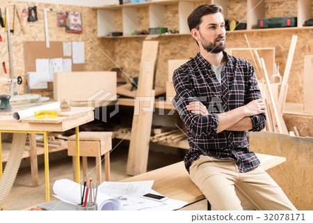 Pensive woodworker is resting at work Pensive woodworker is resting at work 32078171