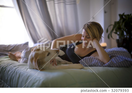woman with her dog in the bed at home 32079393