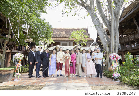 Groom and bride are taking photo with their guests at their wedding ceremony.  32090248
