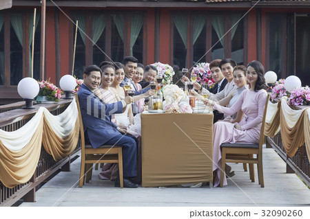 Guests are holding wine glasses and smiling at a wedding ceremony 32090260