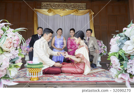 Parents are looking their daughter giving wedding ring to her husband 32090270