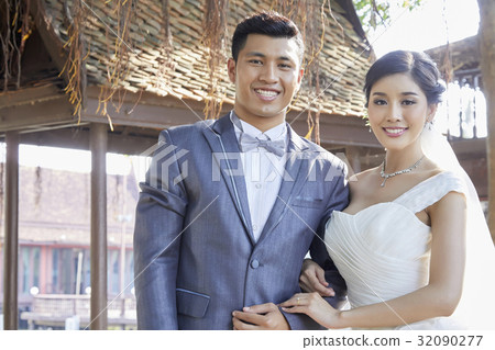 the bride and the groom are standing side by side and smiling the bride and the groom are standing side by side and smiling 32090277
