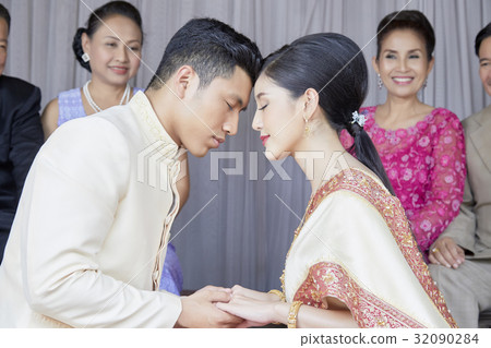 the couple are closing their eyes and holding hand each other the couple are closing their eyes and holding hand each other 32090284