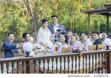 the married couple are standing and toasting happily with guests the married couple are standing and toasting happily with guests 32090376