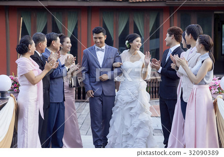 guests are clapping for the happy bride and groom outdoors 32090389