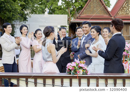 guests are clapping for happy newlyweds outdoors 32090400