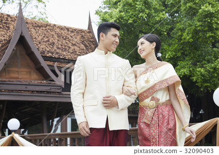 asian thai groom and bride are looking at each other and smiling asian thai groom and bride are looking at each other and smiling 32090403