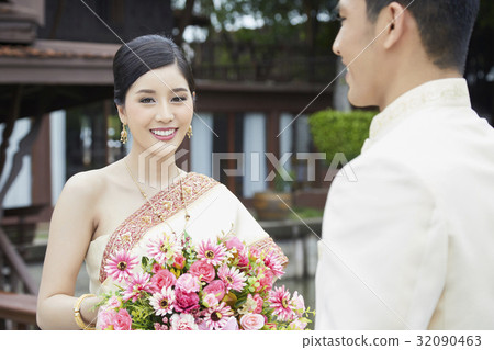 A portrait of a Thai bride smiling next to her groom. A portrait of a Thai bride smiling next to her groom. 32090463