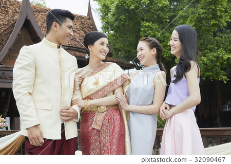 A couple is talking happily with their friends. 32090467