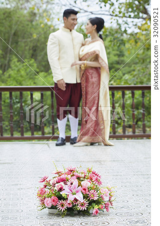 a photo of flowers on a floor near groom, bride standing and looking together a photo of flowers on a floor near groom, bride standing and looking together 32090521