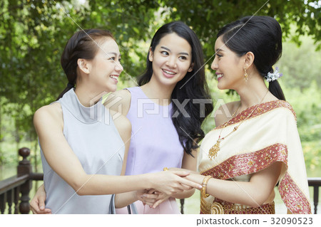 a photo of a bride and two girls taking hands and smiling together a photo of a bride and two girls taking hands and smiling together 32090523