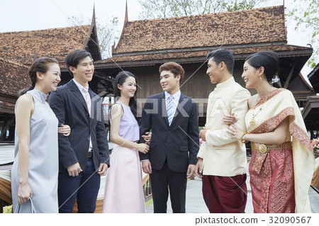 A married couple is standing and having fun together with friends. 32090567