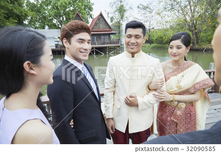 a photo of a bride and groom smiling while greeting their guests. 32090585
