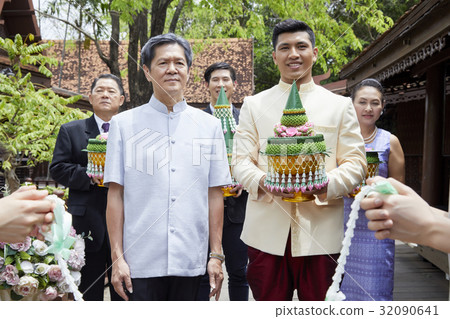 A photo of a groom's family holding Thai traditional wedding gift. A photo of a groom's family holding Thai traditional wedding gift. 32090641