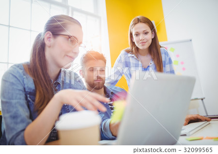 Creative business people looking at laptop Creative business people looking at laptop 32099565