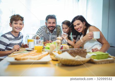 Portrait of happy family having breakfast together 32099582