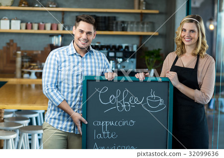 Waitress and man standing with menu board in cafe Waitress and man standing with menu board in cafe 32099636