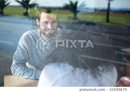 Man talking to a woman in coffee shop 32099678