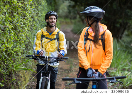 Biker couple interacting while cycling in countryside 32099686