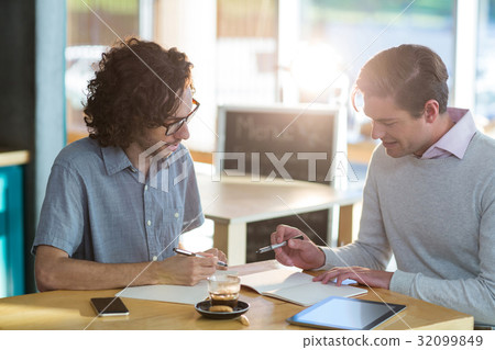Male friends discussing over document 32099849