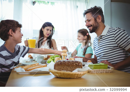 Happy family having breakfast 32099994