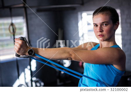 Portrait of female athlete stretching resistance band Portrait of female athlete stretching resistance band 32100002