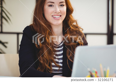 Portrait of confident executive using laptop at office 32100271