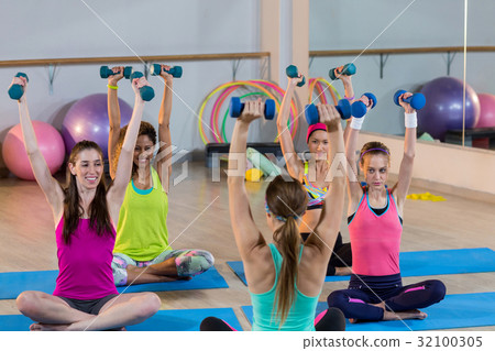 Group of women exercising with dumbbell Group of women exercising with dumbbell 32100305
