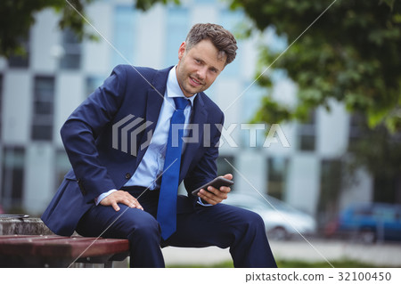 Portrait of handsome businessman holding mobile phone Portrait of handsome businessman holding mobile phone 32100450