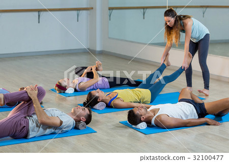 Yoga instructor helping student with a correct pose 32100477