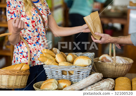 Mid section of woman purchasing bread 32100520