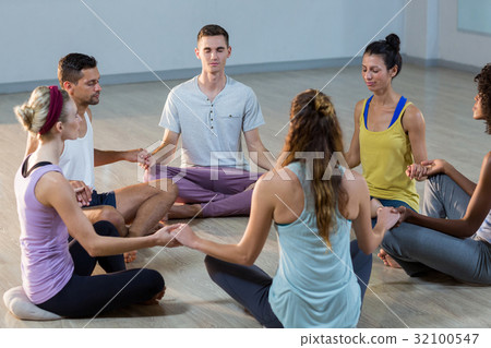 Group of people performing yoga 32100547