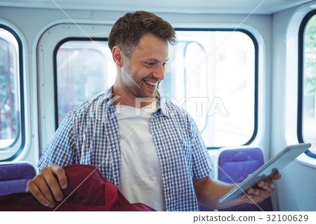 Handsome man using digital tablet in train Handsome man using digital tablet in train 32100629