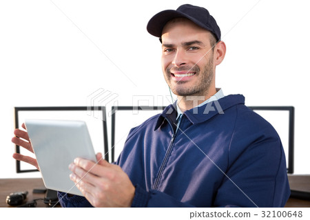 Happy security officer using digital tablet at desk Happy security officer using digital tablet at desk 32100648