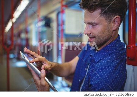 Handsome man using digital tablet in train 32100680