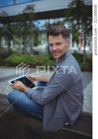 Portrait of handsome business executive using laptop 32100686