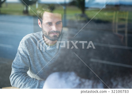 Man talking to a woman in coffee shop 32100783